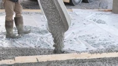 There is concrete mixing truck in middle of new home pouring concrete for pavement
