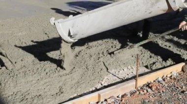 Beton karıştırma kamyonunun yardımıyla yeni evin etrafında asfalt döşeniyor.