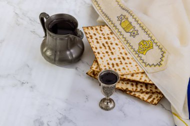 Traditional Passover food consists of unleavened matzah bread and kosher kiddush cup wine during Pesach