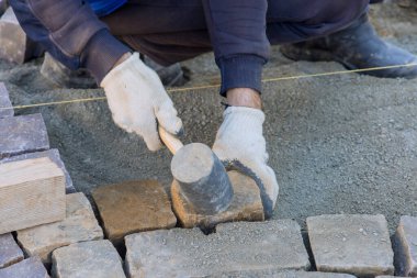 Worker were able to create an even stable pavement by using industrial cobblestones along with granite stones.