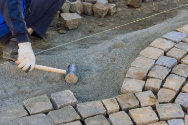 Paving of street with granite stones was laborious task that required skilled workers to use industrial cobblestones.