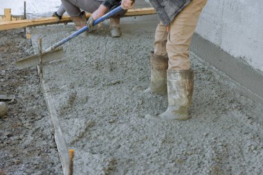 Beton döktükten sonra kaldırımı düzleştirmek için uzun malalar kullanmış..