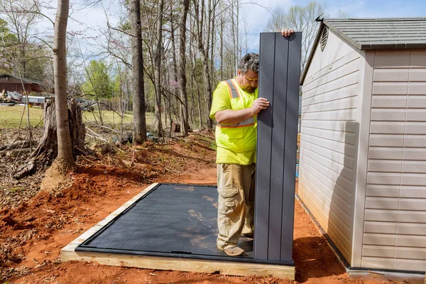 stock image Job by worker assembling plastic shed for backyard near house