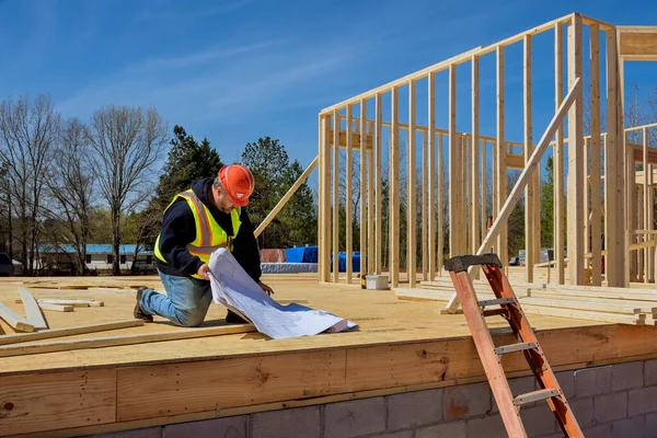 Inspector checks construction of new home using construction plan