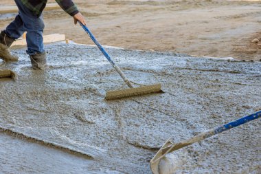 İşçiler dökülen betonun düzleştirilmesini sağlamak için çeşitli araçlar kullandılar.