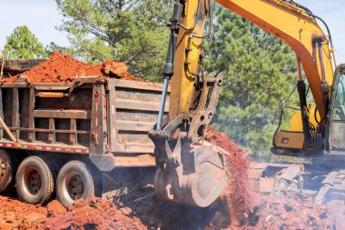 Kazı kovası topraktan çıkarılıyor ve başka bir yere taşınıyor..