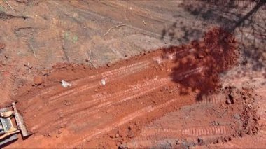 İnşaat alanındaki karada ilerlerken bir kazıcı kepçesi hareket ediyor ve dengeleniyor