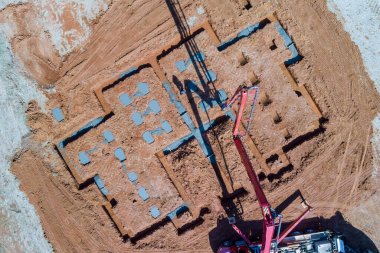 İnşaat işçisi ev temeline beton dökmek için beton pompa kullanıyor