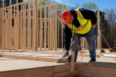 Müteahhit yeni ahşap evi çerçevelemek için çivi çakıyor..