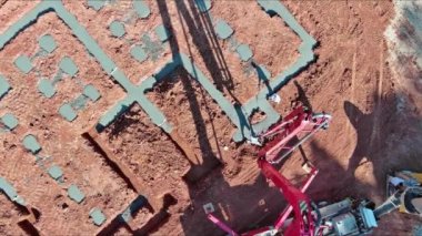 İşçiler binanın temeli için otomatik pompa kullanarak beton dökerken,