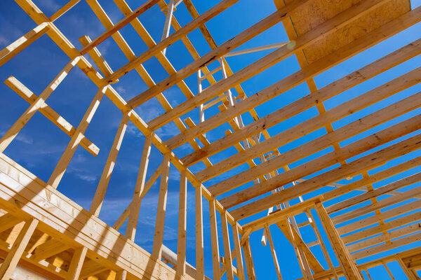 Using an existing framework trusses frame wooden roof beam to support roof of newly constructed stick house