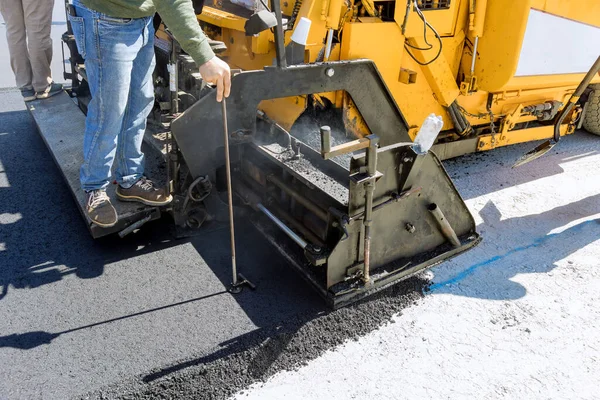 Steam roller an asphalt paver machine are used during construction new road as part of layering process