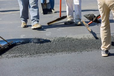 İnşaat işçisi asfaltlama sürecinin bir parçası olarak yeni asfalt yollar inşa ediyor