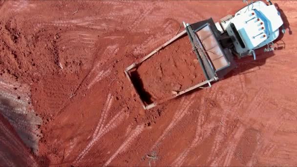 ダンプトラックは建設現場の土壌レベリング地面を移動しています — ストック動画