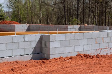 On construction site cement blocks are laid for walls that will support foundation of house. clipart