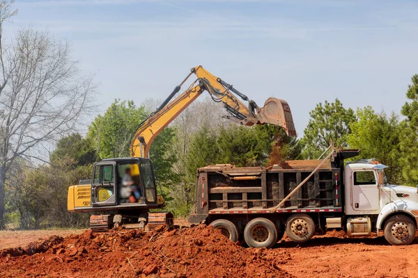 Camión Volquete Está Cargando Tierra Una Excavadora Sitio Construcción — Foto de Stock