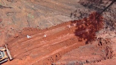 İnşaat alanındaki karada ilerlerken bir kazıcı kepçesi hareket ediyor ve dengeleniyor