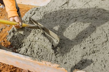 Beton döktükten sonra kaldırımı düzleştirmek için uzun malalar kullanmış..