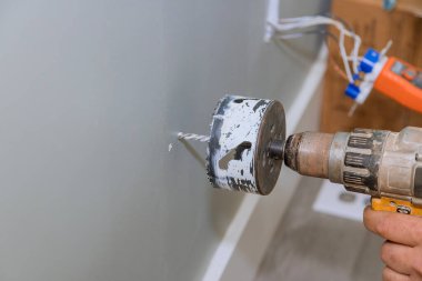 Duvara elektrik kablosu yerleştirmek için alçıpan delmek görevlerden biri