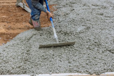 Otopark için beton yollar inşaat alanında işçiler tarafından dolduruluyor.