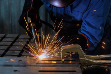 Fabrikada duman çıkaran, çelik kaynak yapan bir işyeri.