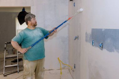 Tamirat sırasında apartman odasının yenilenmesi ve geliştirilmesi. Tamir sırasında duvarları beyaz tekerlekli boyayla boyamak.