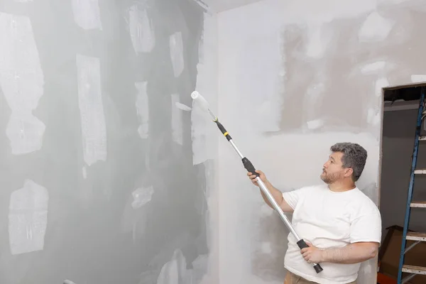 stock image Apartment room was updated, improved during repairs, using roller to paint walls with white paint