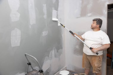Tamir sırasında bir apartman odasının geliştirilmesi, duvarların kaygan beyaz boyayla boyanması