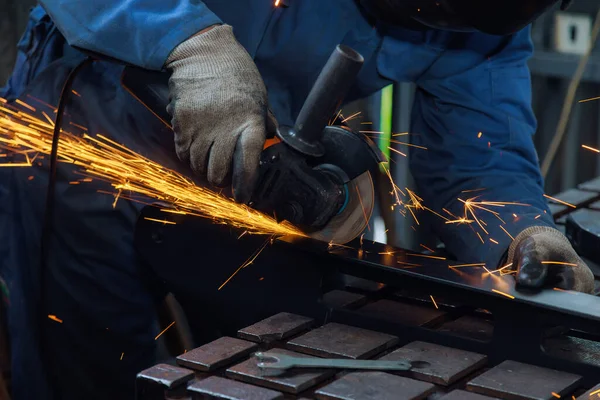 stock image Metalwork workplace with master grinding metal grinder sparks in factory as he works with it