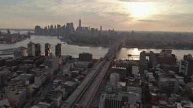 Williamsburg Köprüsü 'nün panoramik manzarası Doğu Nehri boyunca canlı günbatımına karşı Brooklyn' den izleniyor