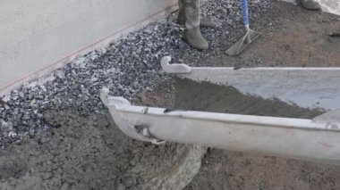 Pavement is being laid around new house with help of concrete mixing truck