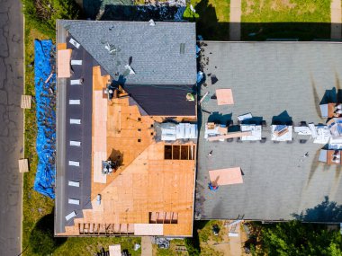 Eski çatıyı yeni kiremitler ve kontraplaklarla değiştirerek bir apartmanın çatısı onarıldı