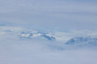 Bulutlar zaten güzel olan Grönland dağ zirvelerine mistik dokunuşlar ekler ve büyüleyici bir manzara yaratır.