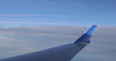 Muhteşem mavi gökyüzü arka planına sahip bir uçağın kanadında uçarken pencere görünümü