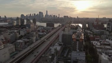 Brooklyn, New York 'taki Williamsburg Köprüsü gün batımında nefes kesici panoramik manzara sunuyor.