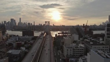 Resimli günbatımı, Williamsburg Köprüsü 'nün doğu nehri üzerindeki manzarasını büyüleyici bir manzaraya dönüştürüyor..