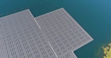 Hava görüntüsü, göl yüzeyinde görsel olarak çarpıcı alternatif enerji enerjisi yaratan geniş güneş panelleri dizisini sergiliyor.