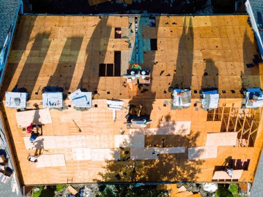 Bir apartmanın çatısını onarmak için yeni kiremitler monte edildi ve eskilerinin yerine kontrplak yerleştirildi.