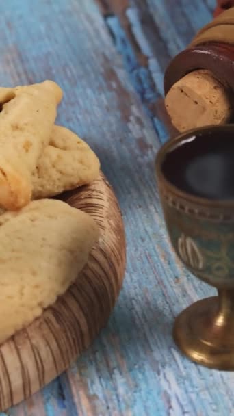 プリム祭りはクッキーで祝われるユダヤ教の宗教祭です音作りのノイズメーカーの高いカーニバルマスクとお祝いのシンボルとしてHamantaschens — ストック動画