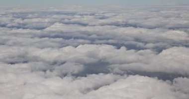 Güzel mavi kabarık bulutların üzerindeki bir uçak penceresinden güzel manzaralar yeşil manzarayı güzelleştirir.