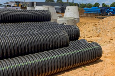 İnşaat alanında drenaj tahsildarları için siyah plastik borular var.