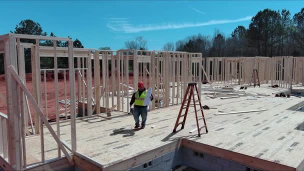 Stavební Inženýr Kontroluje Kvalitní Práce Dřevěného Rámu Pomocí Architektonického Půdorysu — Stock video