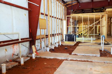 Beton zeminden çıkan birkaç drenaj pvc borusu gelecekteki tuvaletlerin tesisatı için yerleştirildi..