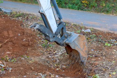 Kanalizasyon beton kanalizasyonuna konaklamak için traktörle hendek kazmak.