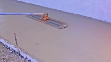 Kaldırım, inşaat alanında beton döken uzun malayla ıslak çimento döktü.