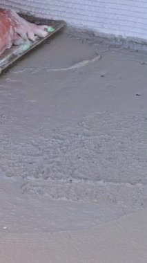 İnşaat alanında ıslak zemini malayla bitiren uzman beton işçisi.