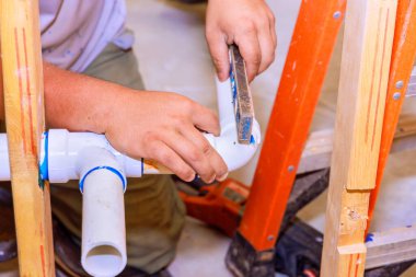 Yeni ev inşaatının duvarına boru tesisatı döşeniyor.