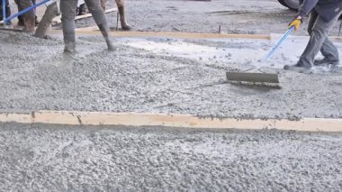 Karıştırıcı kamyonun önünde ıslak çimento dökülüyor garaj yolu için karışık beton hazırlanıyor.
