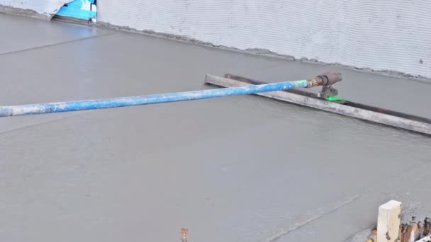 建設現場で長いタオルを使用してコンクリート労働者のレベルを濡らした歩道を注ぐ — ストック動画