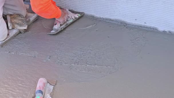 専門家のコンクリート労働者は建設現場のタオルが付いているぬれた床を仕上げます — ストック動画